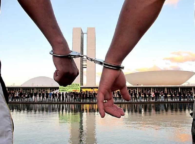 Agentes penitenciários colocam algemas nos punhos em frente ao Congresso Nacional para pedir a derrubada do veto ao projeto que concede porte de arma de fogo à categoria