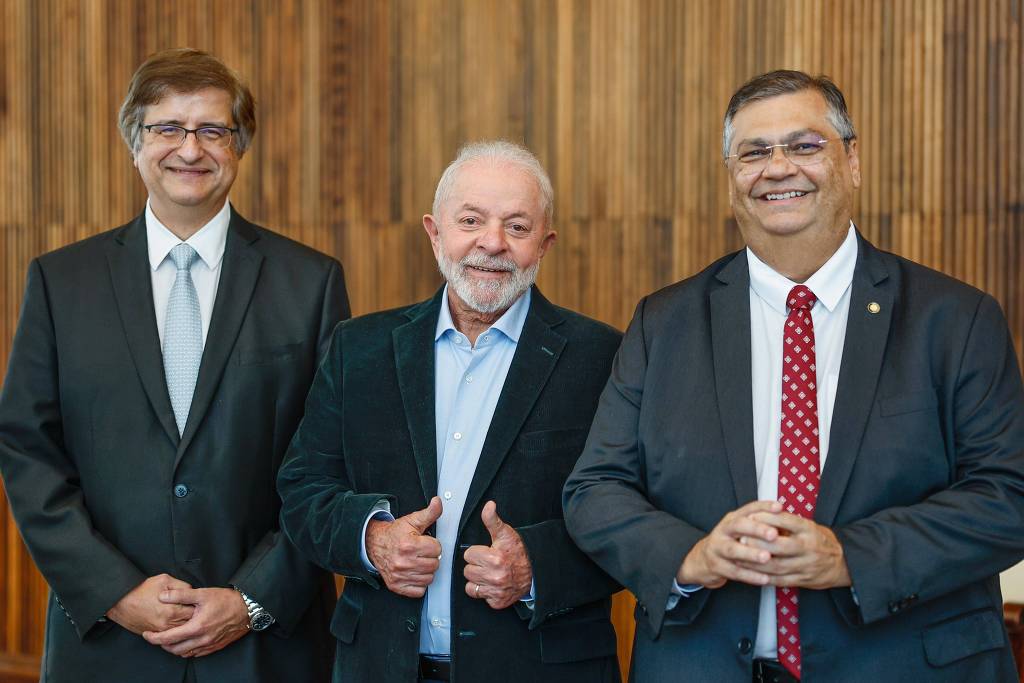 O presidente Lula (PT), ao lado de Paulo Gonet (esq) e Flávio Dino (dir), indicados à PGR e STF, respectivamente.