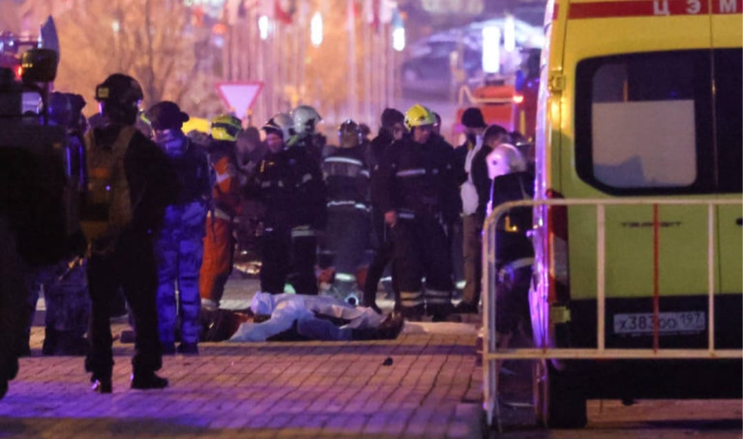 Corpo de pessoa morta durante atentado a casa de espetáculos Crocus City Hall, nos arredores de Moscou, é visto enquanto equipes de emergência inspecionam o local