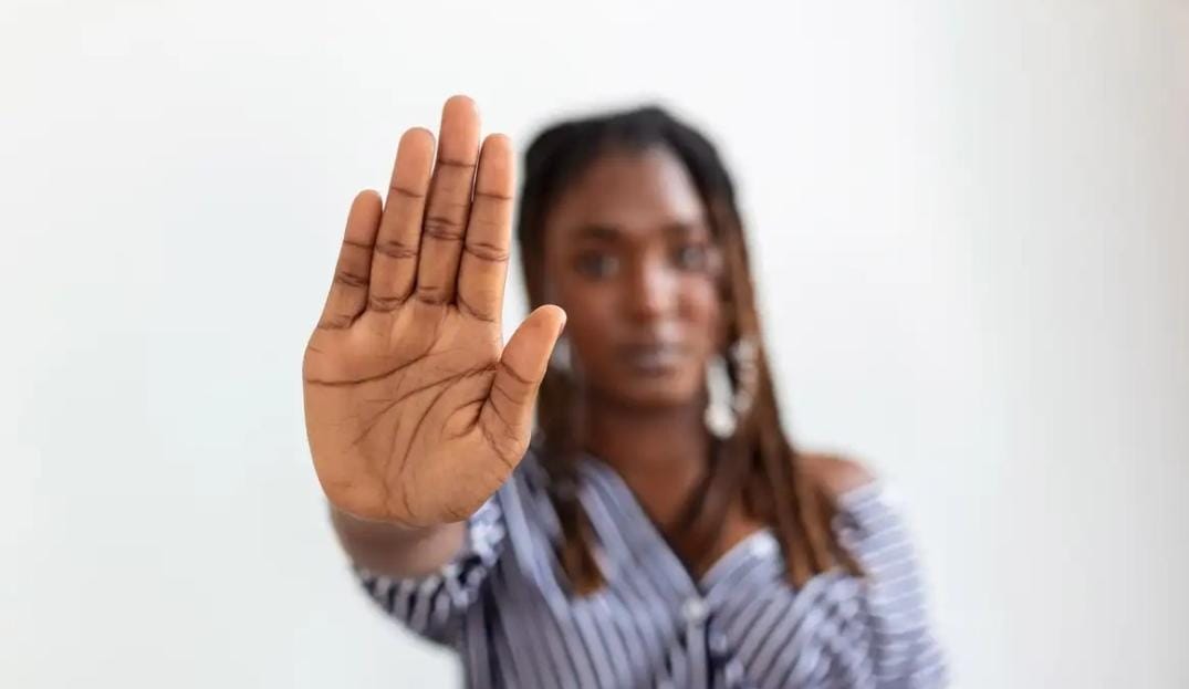 Mulher com a mão para frente com sinal de pare